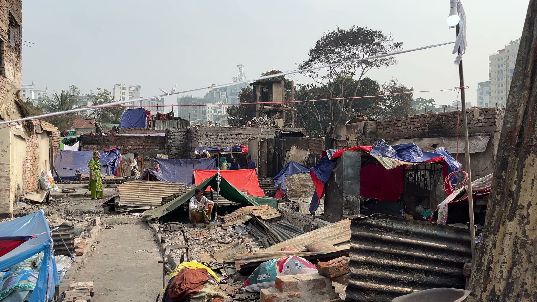 Temporary shelters and fire-damaged homes across the Korail settlement
