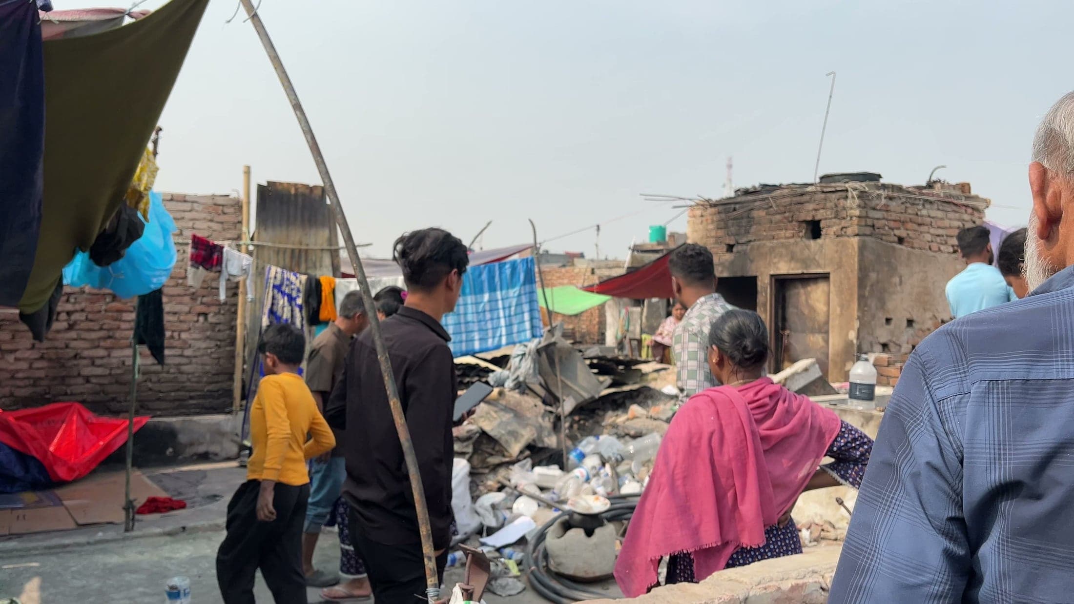 Residents and field volunteers surveying fire damage in Korail