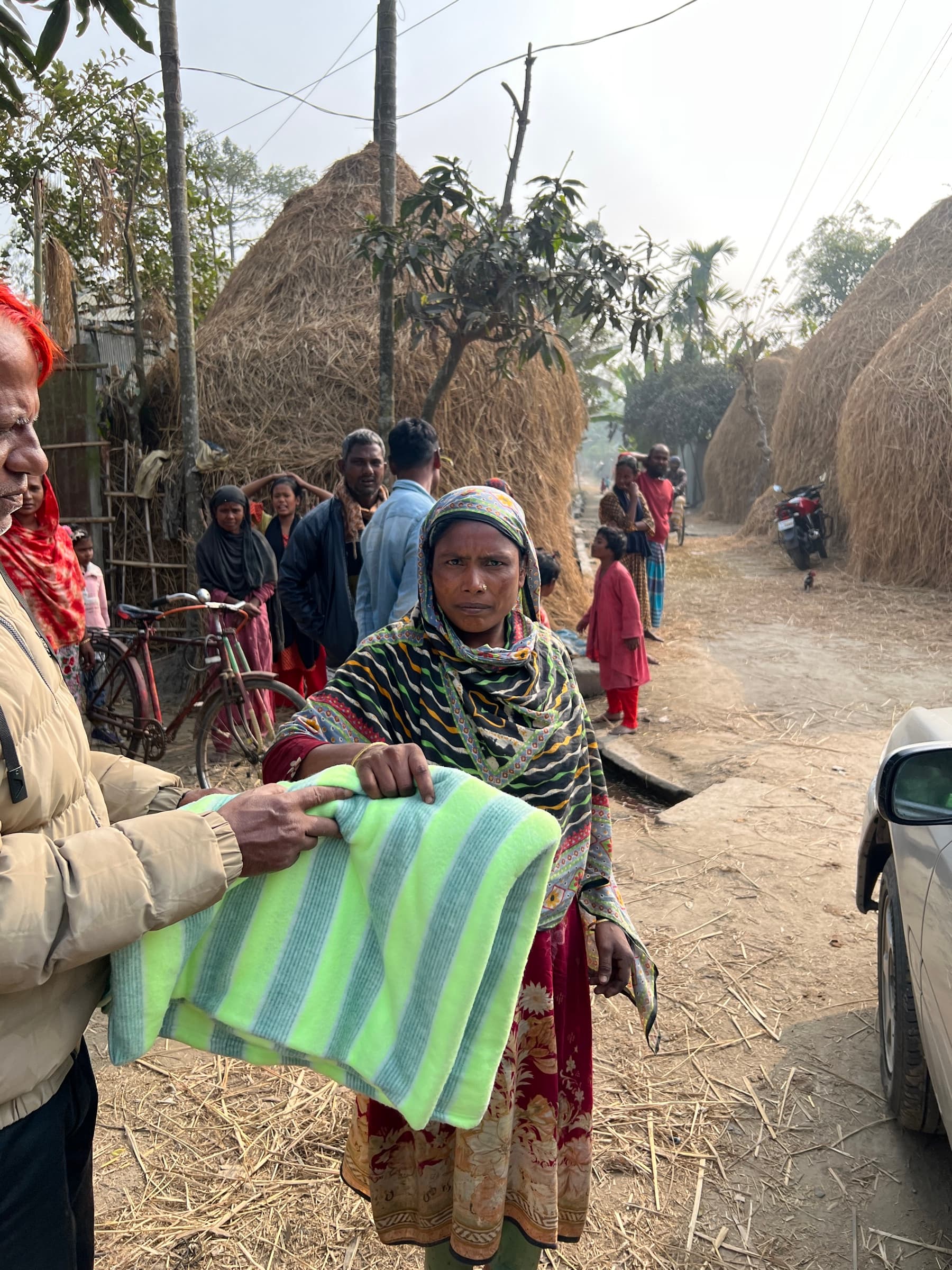 A woman receiving a blanket during the winter relief project
