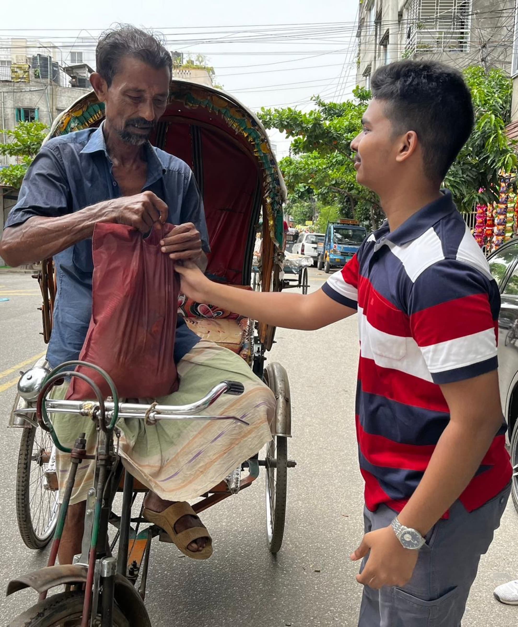 An Eid food package being handed to a rickshaw puller in Dhaka