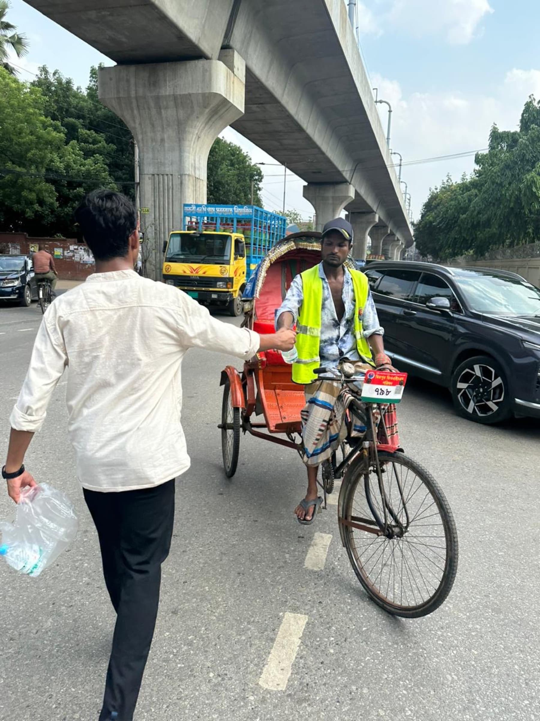 A volunteer preparing water for distribution to a rickshaw puller