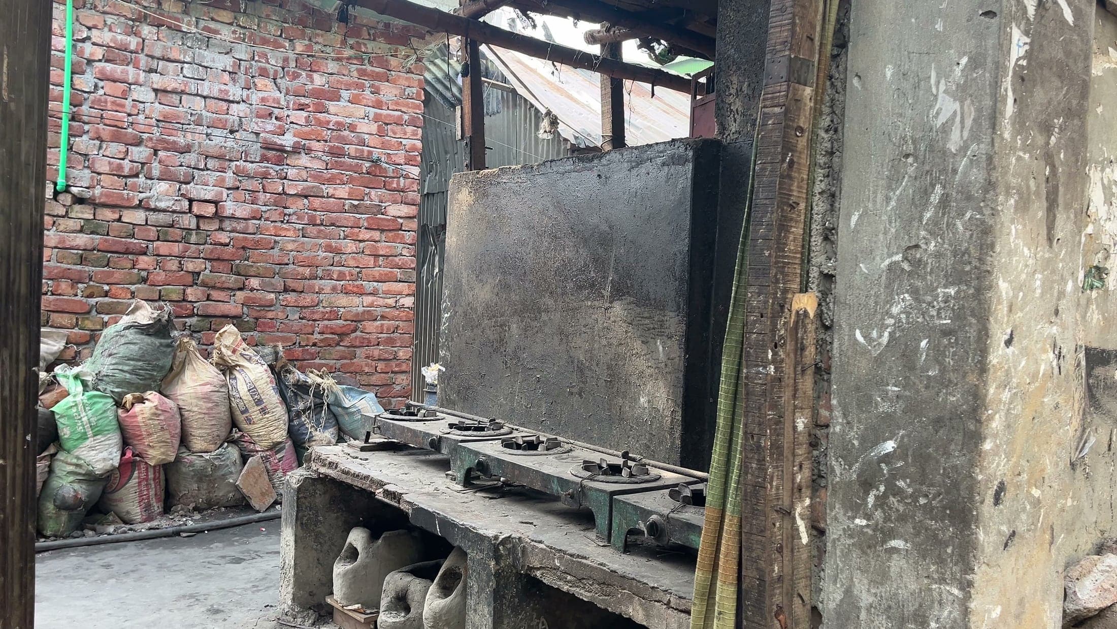 Fire-damaged cooking stoves and walls inside a Korail home
