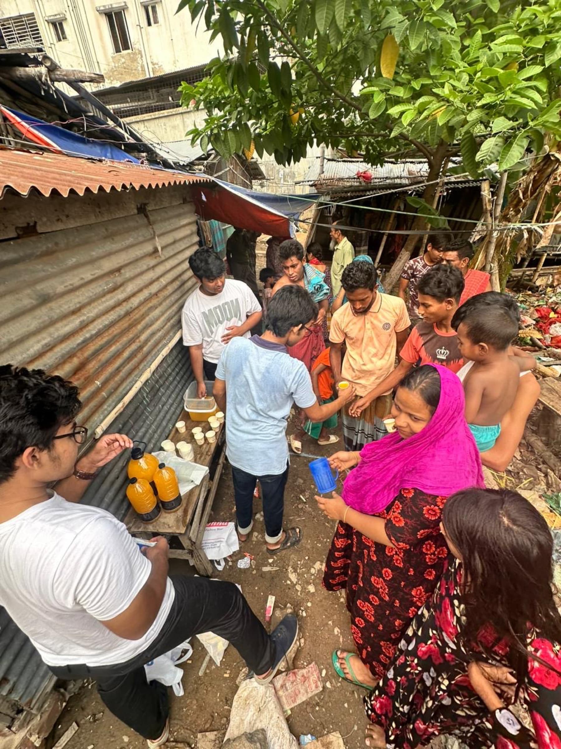 Volunteers distributing food and drinks in a Mirpur community