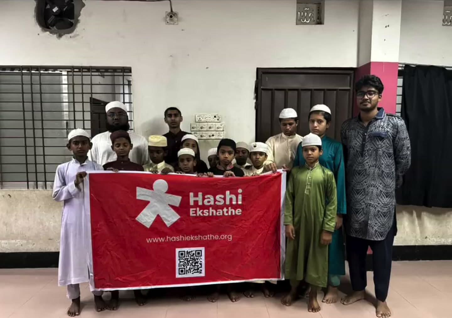 Children and Hashi Ekshathe volunteers after Ramadan food support at a Rangpur madrasa in 2026